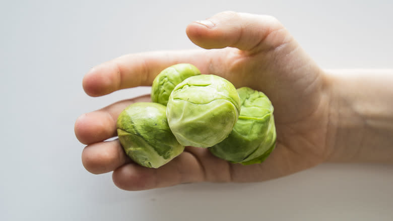 Man holding Brussels sprouts