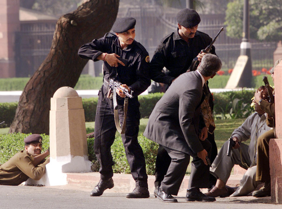 FILE- Indian Black Cat commandos escort civilians outside the Parliament House as half a dozen armed men stormed the complex in New Delhi, India, Dec. 13, 2001. India on Friday, Aug. 12, 2022, criticized China's decision to block the imposition of U.N. sanctions sought by it and the United States against Abdul Rauf Azhar, the deputy chief of Jaish-e-Mohammad, a Pakistan-based extremist group designated by the United Nations as a terrorist organization. India says Azhar was involved in the planning and execution of numerous terror attacks, including the 2001 attack on the Indian Parliament. (AP Photo/John McConnico, File)