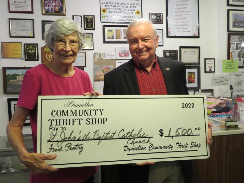 Sandra Marraffino, a volunteer with the Dunnellon Community Thrift Shop, presents a check for $1,500 to Charles Glover, director of the St. John the Baptist Catholic Church Helping Hands Food Pantry.