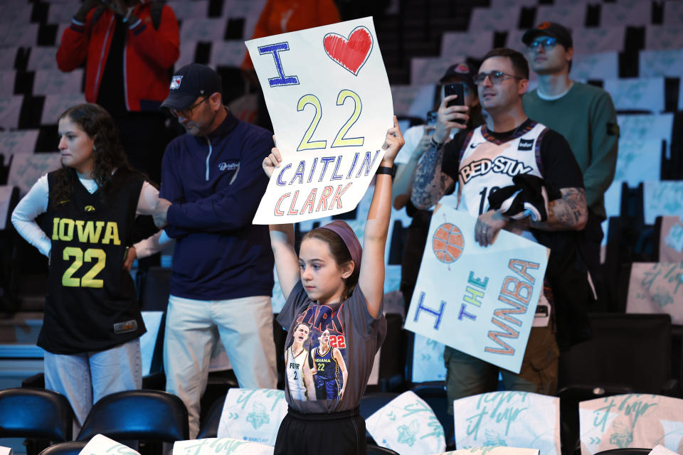 Fans hold up signs for Indiana Fever's Caitlin Clark before the start of a WNBA basketball game against the New York Liberty, Saturday, May 18, 2024, in New York. (AP Photo/Noah K. Murray)