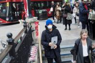 A man wears a protective mask as he walks into Oxford Circus underground station in London