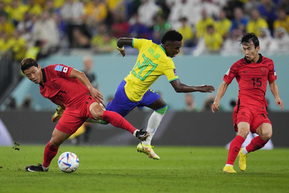 Brazil's Vinicius Junior, center, South Korea's Na Sang-ho, left, and South Korea's Kim Moon-hwan challenge for the ball during the World Cup round of 16 soccer match between Brazil and South Korea, at the Stadium 974 in Al Rayyan, Qatar, Monday, Dec. 5, 2022. (AP Photo/Manu Fernandez)
