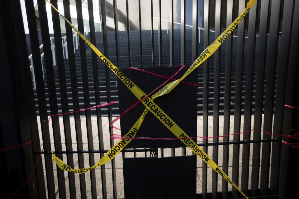 Cintas de precaución colocadas por manifestantes que protestan contra una serie de leyes para eliminar los fideicomisos cubren una entrada al Senado mexicano el miércoles 21 de octubre de 2020 en la Ciudad de México. (AP Foto/Fernando Llano)