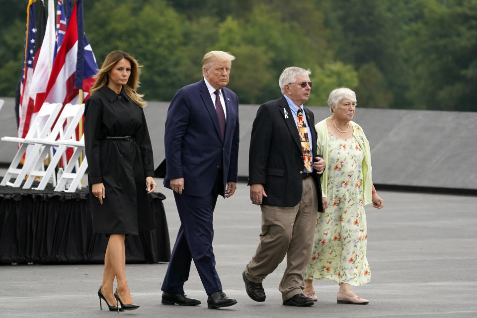 President Donald Trump and first lady Melania Trump walk with Ed Root and his wife Nancy to lay a wreath at a 19th anniversary observance of the Sept. 11 terror attacks, at the Flight 93 National Memorial in Shanksville, Pa., Friday, Sept. 11, 2020. Ed Root's cousin was flight attendant Lorraine Bay. (AP Photo/Alex Brandon)
