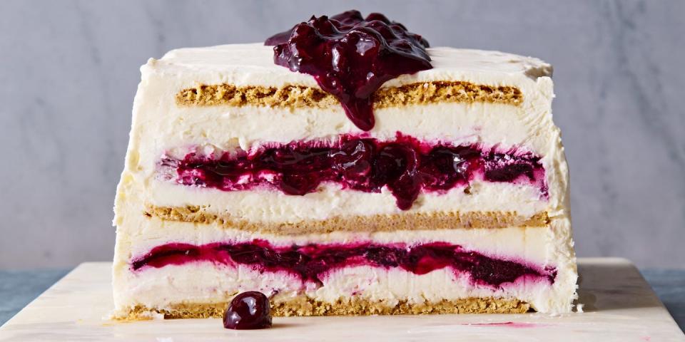 blueberry cheesecake icebox cake with layers of graham crackers, whipped cheesecake, and blueberry jam on a marble slab