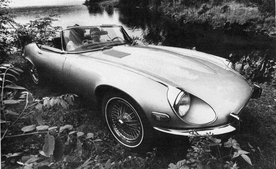 <p><em>October 1972</em></p><p>What We Said: “The cloudlike body contours of the E-type have had to be . . . attacked with a grille opening rudely stretched to admit the cooling air necessary for a thermally overloaded emissions-controlled engine. Further, to mollify National Highway Traffic Safety Administration demands, headlamps now bulge too large for their original recesses and a tack-on set of legal taillamps have destroyed the once lean rear end. . . . The result of the [addition of the V-12 engine] is a more capable sports car, an engine worthy of the exotic classification in cocktail discussions, and upgraded levels of comfort. . . . The additional power transforms the E-type into a contemporary high performance car. . . . It’s the tractable low and mid-range coupled with a freedom from noise and vibration that makes the V-12 engine worth the cost and service penalties.”</p>