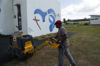 A man works outside the small chapel where Pope Francis will gather with young inmates at the Las Garzas de Pacora detention center, Panama, Wednesday, Jan. 16, 2019. Internees have painted symbols of peace and the logo of the youth festival on walls and chairs in preparation for Francis' visit. (AP Photo/Arnulfo Franco)