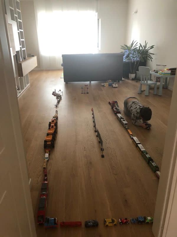 Laura Solaro's son plays alone in the living room, while his parents work in the other rooms of the house, in Milan