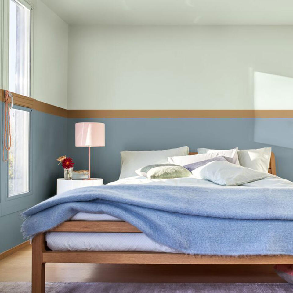 Bedroom with wooden double bed, round side table and blue walls