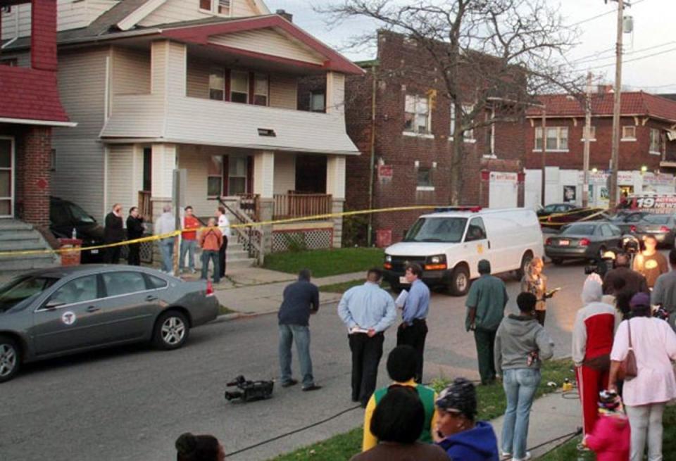 Neighbours watch as Cleveland police search the porch at the home of Anthony Sowell (AP)