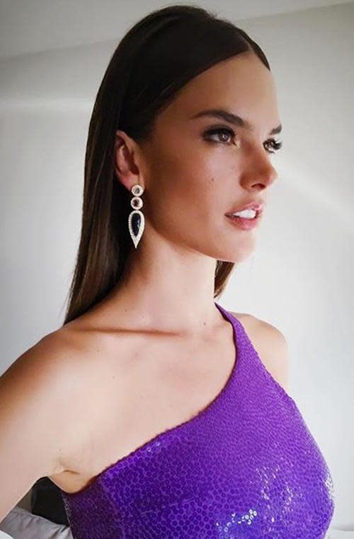 Alessandra Ambrosio stuns as she gets ready in a sequined purple dress.