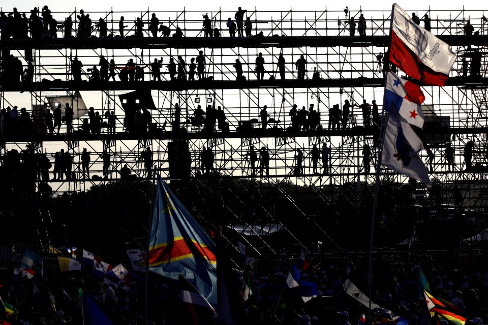 Journalists standing on a press stand are silhouetted against the morning sky as they wait for the arrival of Pope Francis to celebrate an early Mass at the metro park Campo San Juan Pablo II in Panama City, Sunday, Jan. 27, 2019. The Mass marks the formal end to World Youth Day, the once-every-three year religious festival that John Paul launched during his quarter-century pontificate. (AP Photo/Alessandra Tarantino)