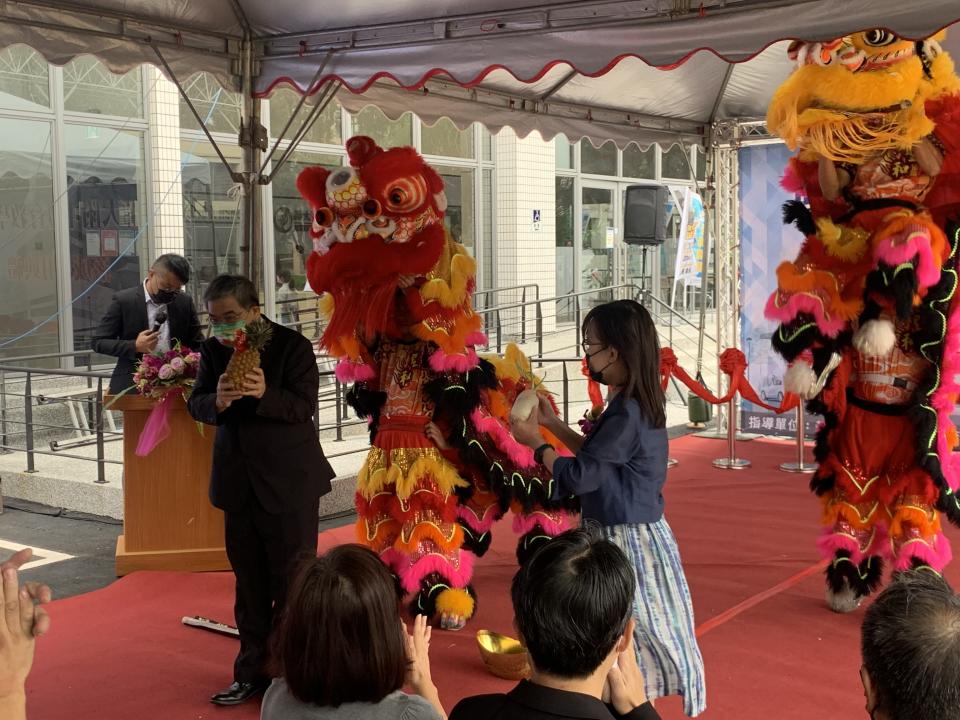 教育部政務次長蔡清華(左)與師大附中校長王淑麗接下舞獅獻瑞的鳳梨象徵好運