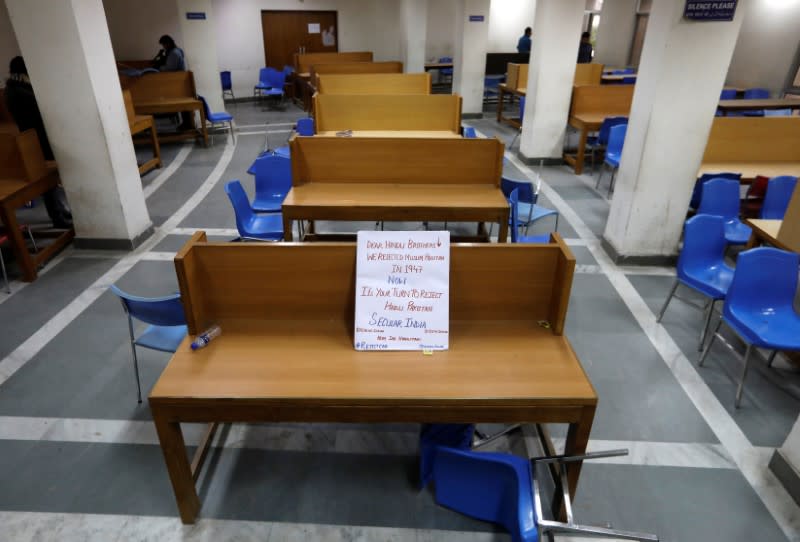 FILE PHOTO: A placard lies on a table inside a partially damaged library of the Jamia Millia Islamia university in New Delhi