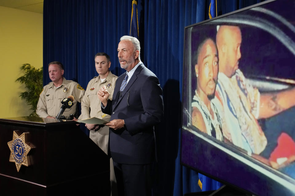 Clark County, Nev., District Attorney Steve Wolfson speaks, with two officers at his right.