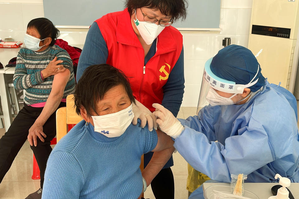 A medical worker administers a dose of a vaccine against coronavirus disease (COVID-19) to an elderly resident, during a government-organized visit to a vaccination center in Zhongmin village on the outskirts of Shanghai, China December 21, 2022. REUTERS/Brenda Goh