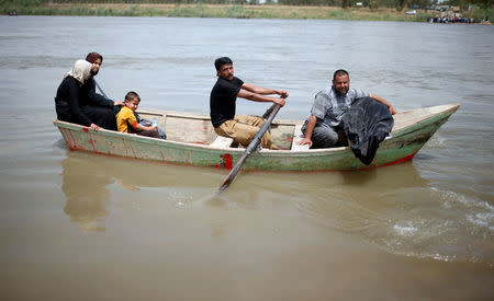 A displaced Iraqi holds the body of his wife, who was killed during the fighting in Mosul, on a boat carrying his family as they cross the Tigris River after the bridge has been temporarily closed, in western Mosul, Iraq May 6, 2017. REUTERS/Suhaib Salem