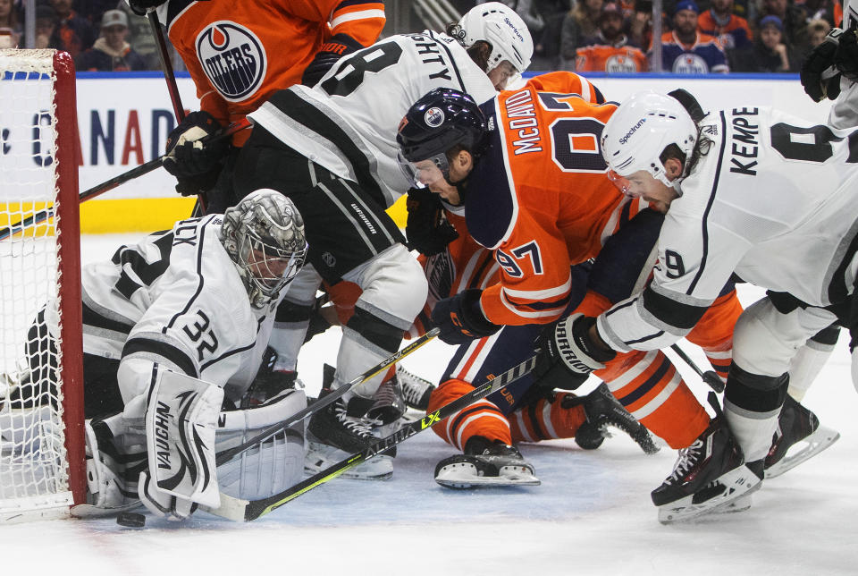 Los Angeles Kings goalie Jonathan Quick (32) makes the save on Edmonton Oilers' Connor McDavid (97) as Adrian Kempe (9) defends during the second period of an NHL hockey game in Edmonton, Alberta, Sunday, Dec. 5, 2021. (Jason Franson/The Canadian Press via AP)