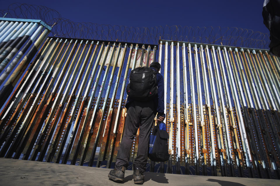 FILE - A migrant waits of the Mexican side of the border after United States Customs and Border Protection officers detained a couple of migrants crossing the US-Mexico border on the beach, in Tijuana, Mexico, Jan. 26, 2022. About 3 in 10 also worry that more immigration can cause native-born Americans to lose their economic, political and cultural influence, according to a poll by The Associated Press-NORC Center for Public Affairs Research. (AP Photo/Marco Ugarte, File)