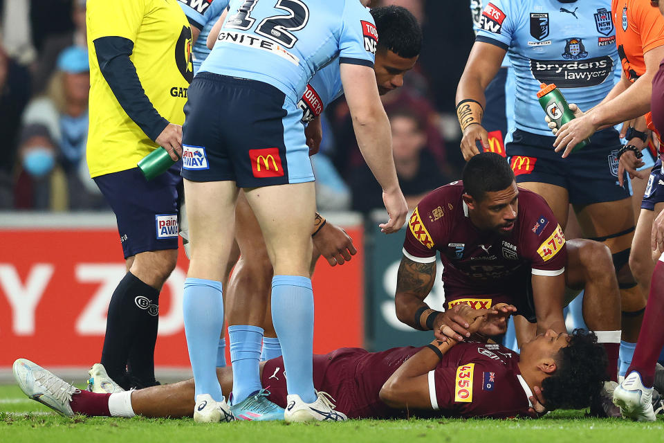 Selwyn Cobbo (pictured on the ground) lays unconscious and is attended to by Dane Gagai (pictured right) during State of Origin.