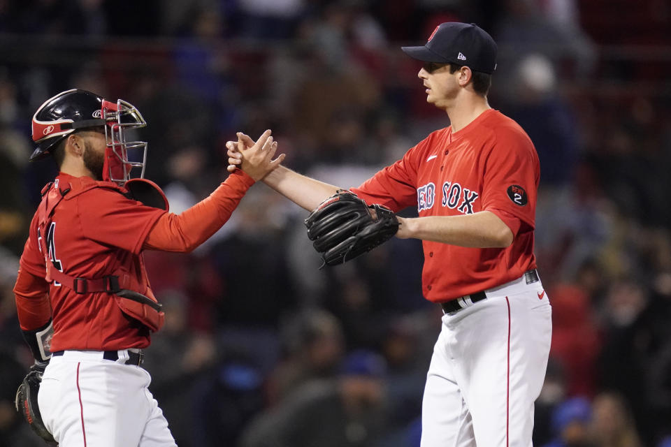 Boston Red Sox relief pitcher Garrett Whitlock, right, is congratulated by Connor Wong after earning a save after defeating the Toronto Blue Jays 2-1 during a baseball game, Tuesday, April 19, 2022, at Fenway Park in Boston. (AP Photo/Charles Krupa)