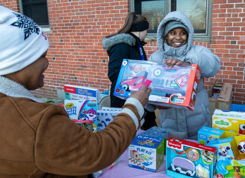 Ida Mota from the Worcester Housing Authority distributes toys at Great Brook Valley Thursday.