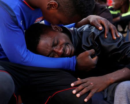 A migrant is comforted by a friend after being rescued, on the Migrant Offshore Aid Station (MOAS) ship Topaz Responder, around 20 nautical miles off the coast of Libya, June 23, 2016. REUTERS/Darrin Zammit Lupi