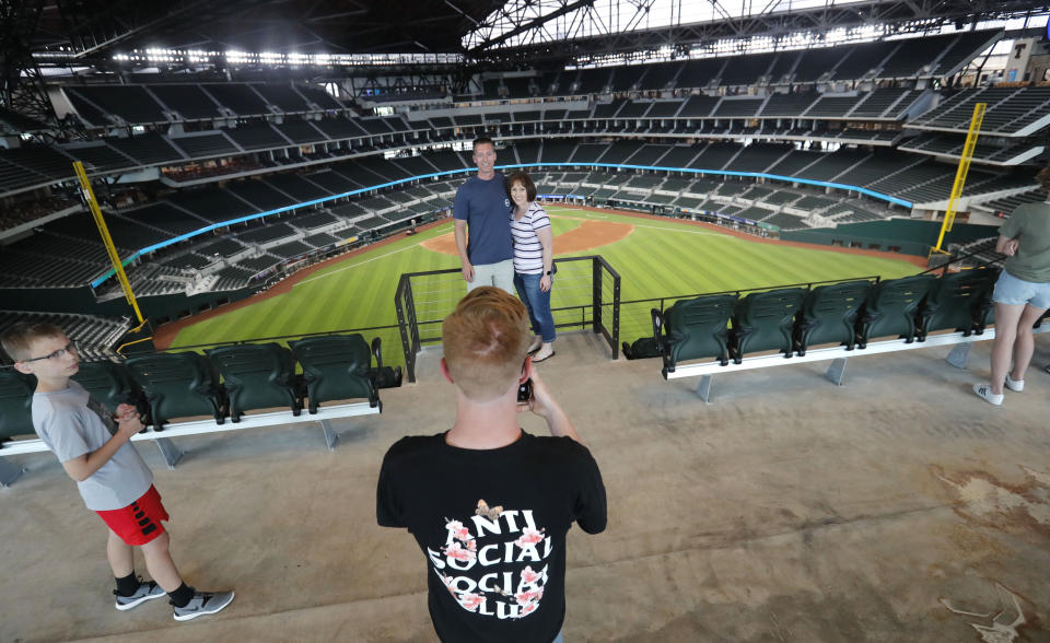 Baseball fans Mark Southard, center left, and his wife Janelle Southard, pose for a photo taken by their son Grayson, 16, as his brother, Gavin, 10, looks on during a tour of Globe Life Field, home of the Texas Rangers baseball team during the first day of public tours in Arlington, Texas, Monday, June 1, 2020. The family drove from their home in Wichita Falls, Texas, to see the team's new home field. (AP Photo/LM Otero)