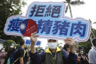 A participant shows a slogan "Anti-ractopamine pork" during a protest in Taipei, Taiwan, Sunday, Nov. 22. 2020. Thousands of people marched in streets on Sunday demanding the reversal of a decision to allow U.S. pork imports into Taiwan, alleging food safety issues. (AP Photo/Chiang Ying-ying)