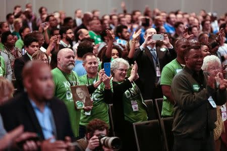 People applaud after the singing of the National Anthem during the Democratic National Committee winter meeting in Atlanta, Georgia February 25, 2017. REUTERS/Chris Berry