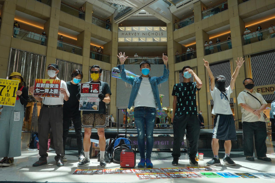 Protesters gather at a shopping mall in Central during a pro-democracy protest against Beijing's national security law in Hong Kong, Tuesday, June 30, 2020. Hong Kong media are reporting that China has approved a contentious law that would allow authorities to crack down on subversive and secessionist activity in Hong Kong, sparking fears that it would be used to curb opposition voices in the semi-autonomous territory. The placard, second from left, reads: "Oppose Beijing's national security law, go to streets on July 1." (AP Photo/Vincent Yu)