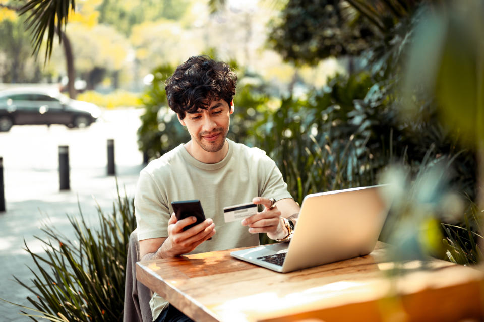 Man holding a phone and credit card