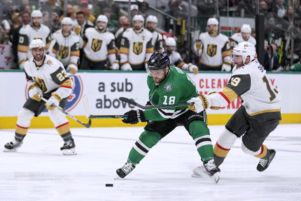 Dallas Stars center Max Domi (18) attempts to take control of the puck as Vegas Golden Knights right wing Reilly Smith (19) defends during the third period of Game 4 of the NHL hockey Stanley Cup Western Conference finals Thursday, May 25, 2023, in Dallas. (AP Photo/Tony Gutierrez)