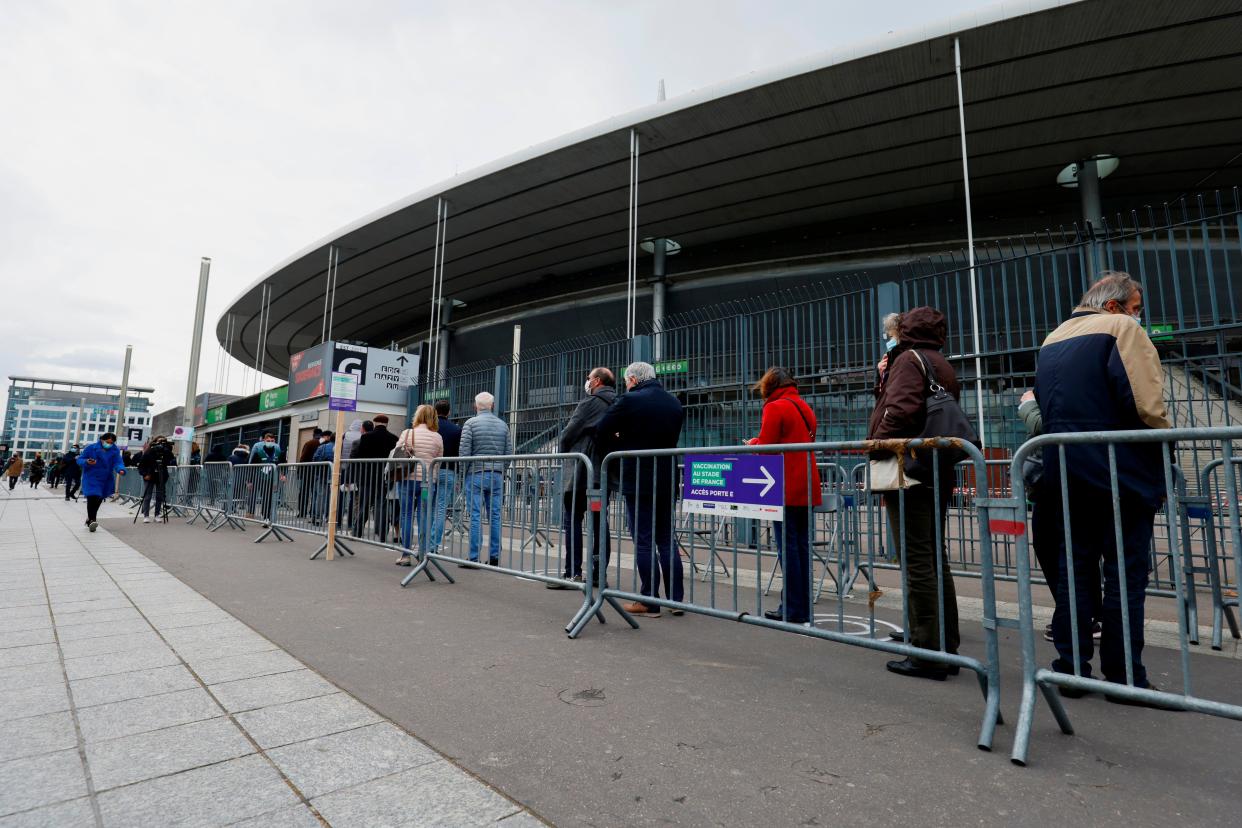 People queue as they arrive at the Stade de France stadium to be vaccinated against COVID-19 in Saint-Denis, outside Paris, Tuesday, April 6, 2021. While France remains far behind Britain and the United States in terms of vaccinating its population, the pace is starting to pick up.