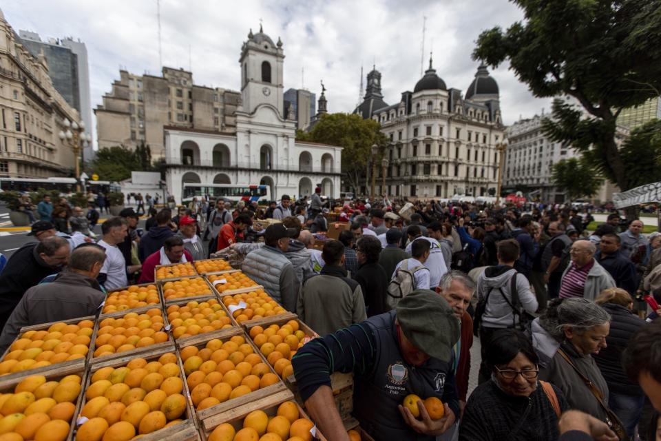 La gente hace fila para recibir fruta gratis frente a la casa de gobierno en Buenos Aires, Argentina, el martes 23 de abril de 2019. (AP Foto / Tomás F. Cuesta)