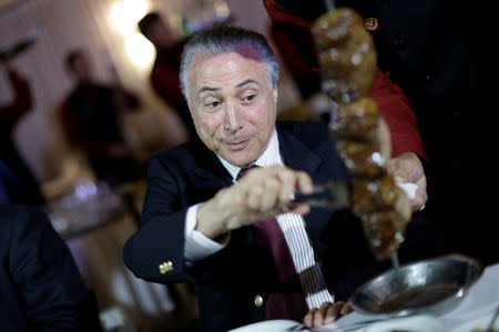 Brazil's President Michel Temer eats barbecue in a steak house after a meeting with ambassadors of meat importing countries of Brazil, in Brasilia, Brazil March 19, 2017. REUTERS/Ueslei Marcelino