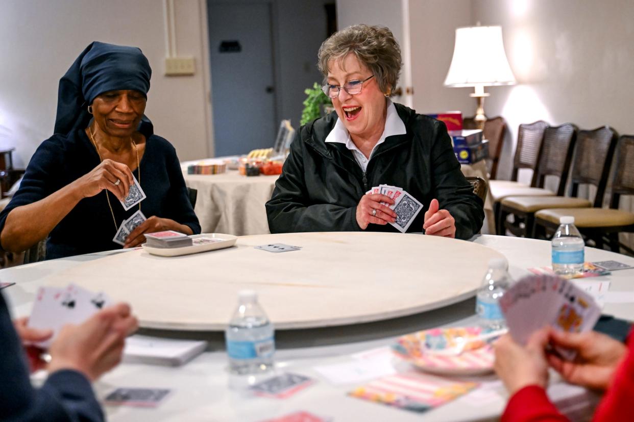Life's Landscapes program director Debbie Sydlowski, right, laughs while playing cards with Sue Forbrush on Thursday, April 11, 2024, at Gorsline Runciman Funeral Homes in East Lansing. The game day is one of several Living Information For Today events that brings together those dealing with loss to offer social support.
