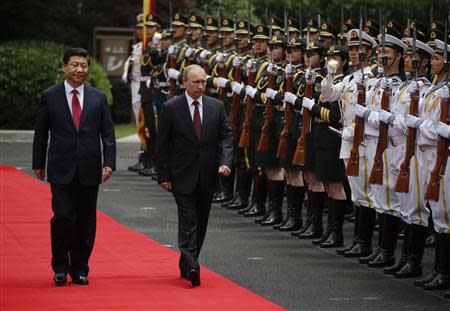 Russia's President Vladimir Putin (R) and China's President Xi Jinping review an honour guard contingent during a welcoming ceremony at the Xijiao State Guesthouse ahead of the fourth Conference on Interaction and Confidence Building Measures in Asia (CICA) summit, in Shanghai May 20, 2014. REUTERS/Carlos Barria