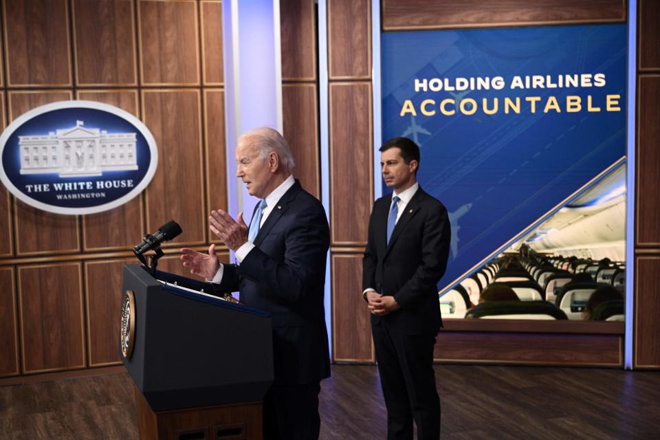 US Transportation Secretary Pete Buttigieg listens to President Joe Biden deliver remarks on protecting consumers when there are flight delays or cancellations in Washington, DC, on May 8, 2023. (Photo by Brendan SMIALOWSKI / AFP) (Photo by BRENDAN SMIALOWSKI/AFP via Getty Images)
