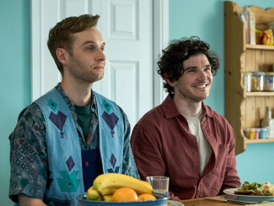 A still from Lost Boys and Fairies showing the two main cast members sitting at a table eating lunch