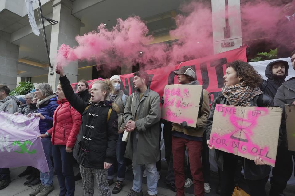 Environmental protesters shout slogan during the Oily Money Out protest outside the Intercontinental Hotel, in London, Tuesday, Oct. 17, 2023. (AP Photo/Kin Cheung)