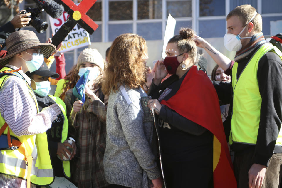 Protesters face off after one protester, center, interrupted a speech during a rally in Canberra, Australia, on Friday, June 5, 2010, prompted by the death of George Floyd, who died after being restrained by Minneapolis police officers on May 25. Thousands gathered in Australia's capital to remind Australians that the racial inequality underscored by Floyd's death was not unique to the United States. (AP Photo/Rod McGuirk)