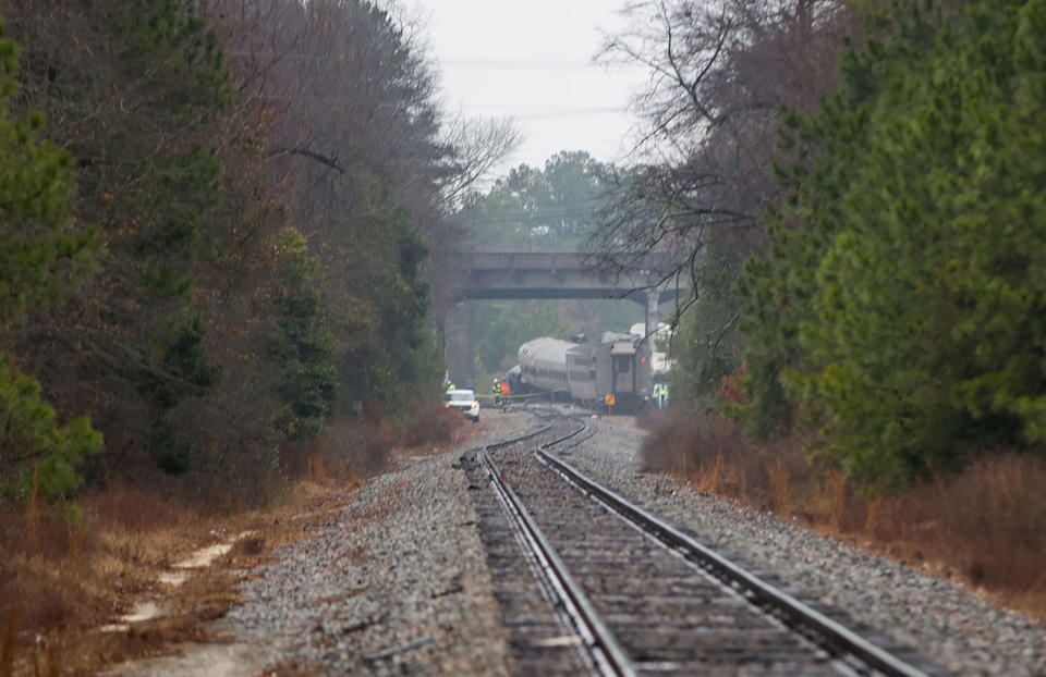 <p>A derailed Amtrak car can be seen up the tracks near a crossing after an early morning collision with a CSX freight train on February 4, 2018 in Cayce, South Carolina. (Photo: Logan Cyrus/AFP/Getty Images) </p>