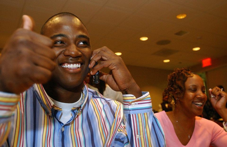 Demarcus Ware, seated next to fiancee Taniqua Smith in his hometown of Auburn, Ala., gives the thumbs up that the Dallas Cowboys are calling to notify him he will be their first-round draft pick, Saturday, April 23, 2005.