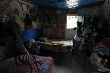 A woman, who is planning to migrate illegally to the U.S., stands at her home in the small village of Suyatal, outskirts of Tegucigalpa June 25, 2014. REUTERS/Jorge Cabrera