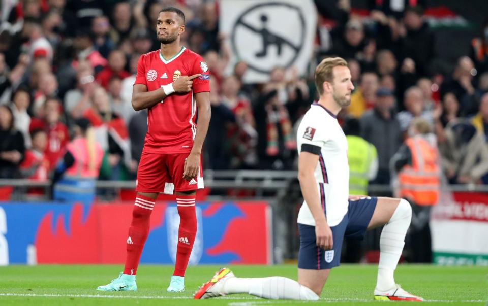 A Hungarian fan holds up a banner showing a line drawn through a picture of a player taking the knee - SHUTTERSTOCK