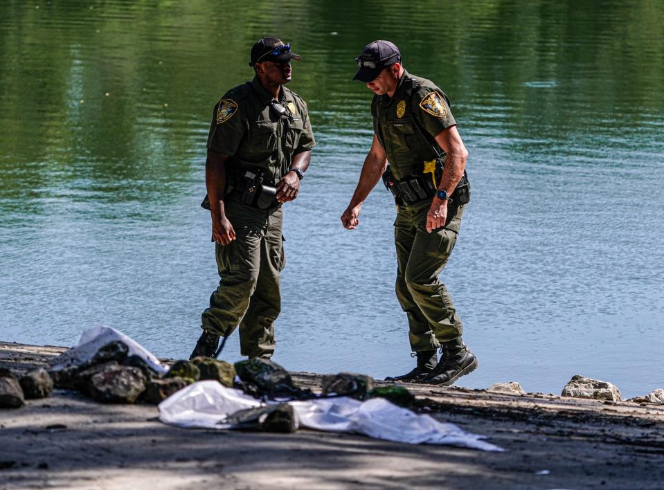 Ind. Conservation officers inspect the boat ramp on Wednesday, July 13, 2022, at a pond in the 2900 block of Bluff Road in Indianapolis. The bodies of Kyle Moorman, who went missing with his three children a week ago, were recovered from the pond the previous evening. 