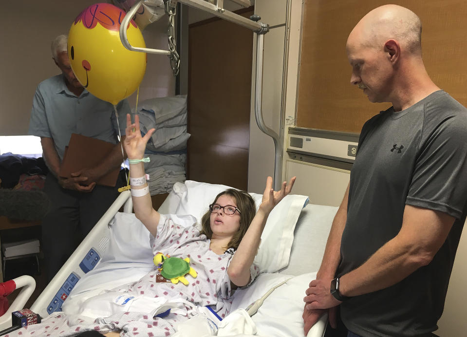 Jessica Tilton, gestures from a hospital bed while talking to reporters about an explosion caused by lava oozing into the ocean that sent molten rock crashing through the roof of a sightseeing boat she was on in Honolulu, Tuesday, July 31, 2018. The July 16, 2018 accident left her with a broken thigh bone, broken pelvis and other injuries. (AP Photo/Jennifer Sinco Kelleher)