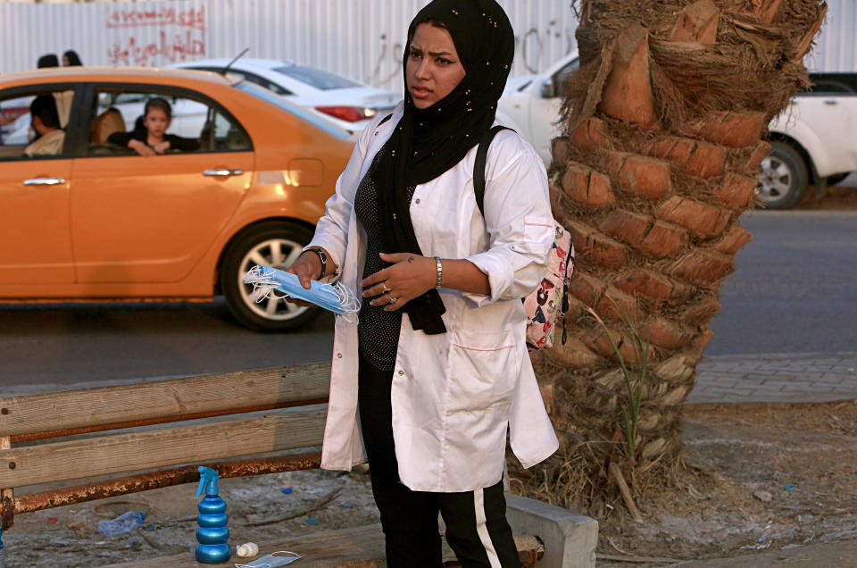 In this Tuesday, Sept. 18, 2018 photo, Hajar Youssif, an Iraqi activist and volunteer medic, who was kidnapped, beaten and threatened for attending protests, waits with first aid supplies at a protest, in Basra, Iraq. Activists say powerful Iranian-backed militias that control Iraq’s oil capital of Basra have waged a campaign of intimidation and arbitrary arrests to silence protests aimed at poor government services and Tehran’s outsized influence in the region. (AP Photo/Nabil al-Jurani)