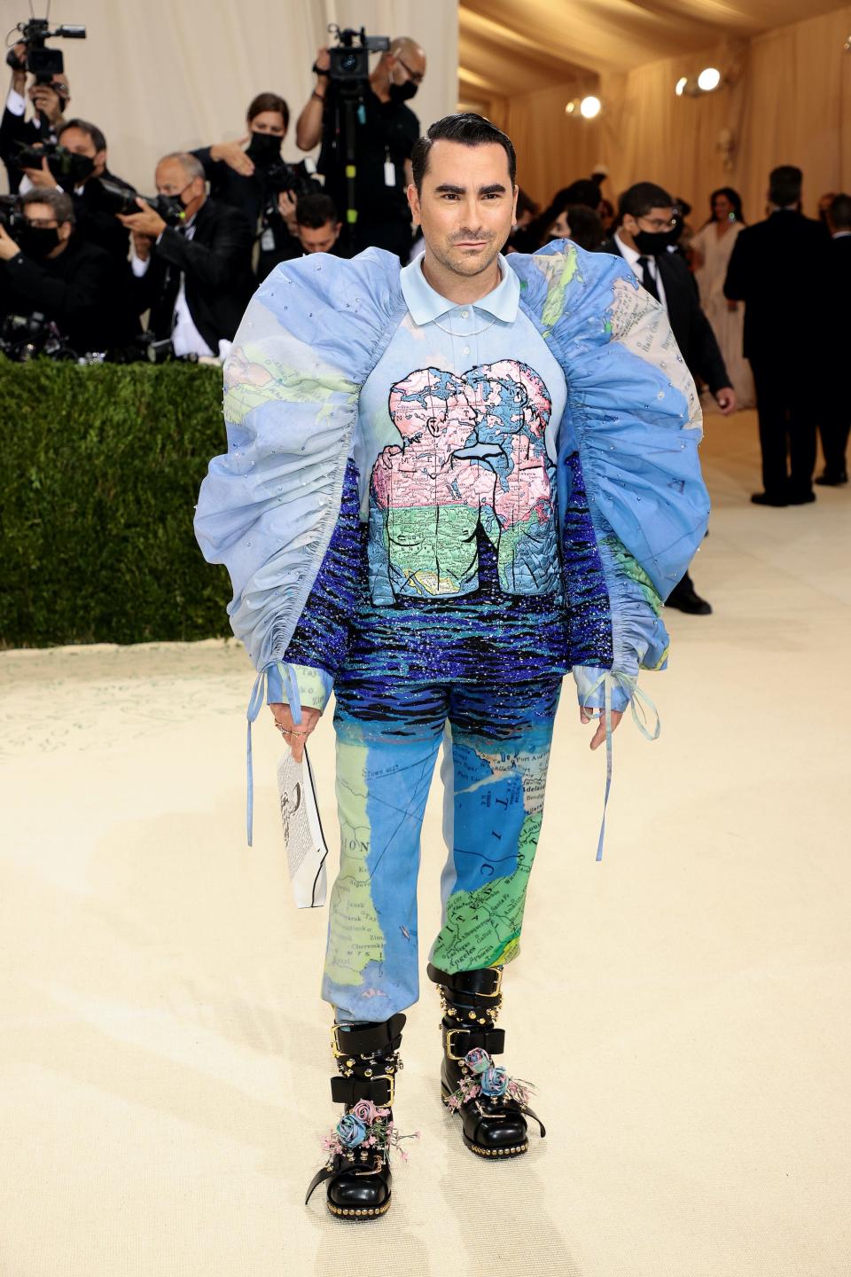 Dan Levy wears a blue outfit on a red carpet.